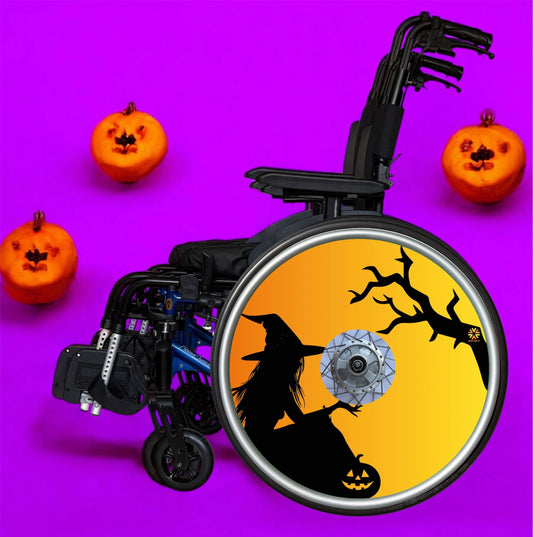 Wheelchair with wheel cover featuring the silhouette of a witch and tree on an orange background.