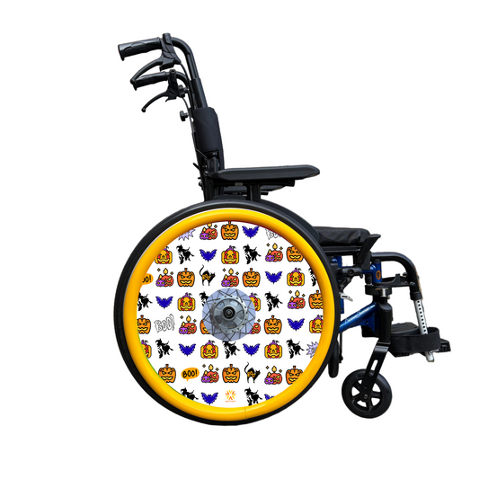 Wheelchair wheel cover on a wheel with orange pushrim covers, Wheel cover features pumpkins, bats, witches and Boo! on a white background.
