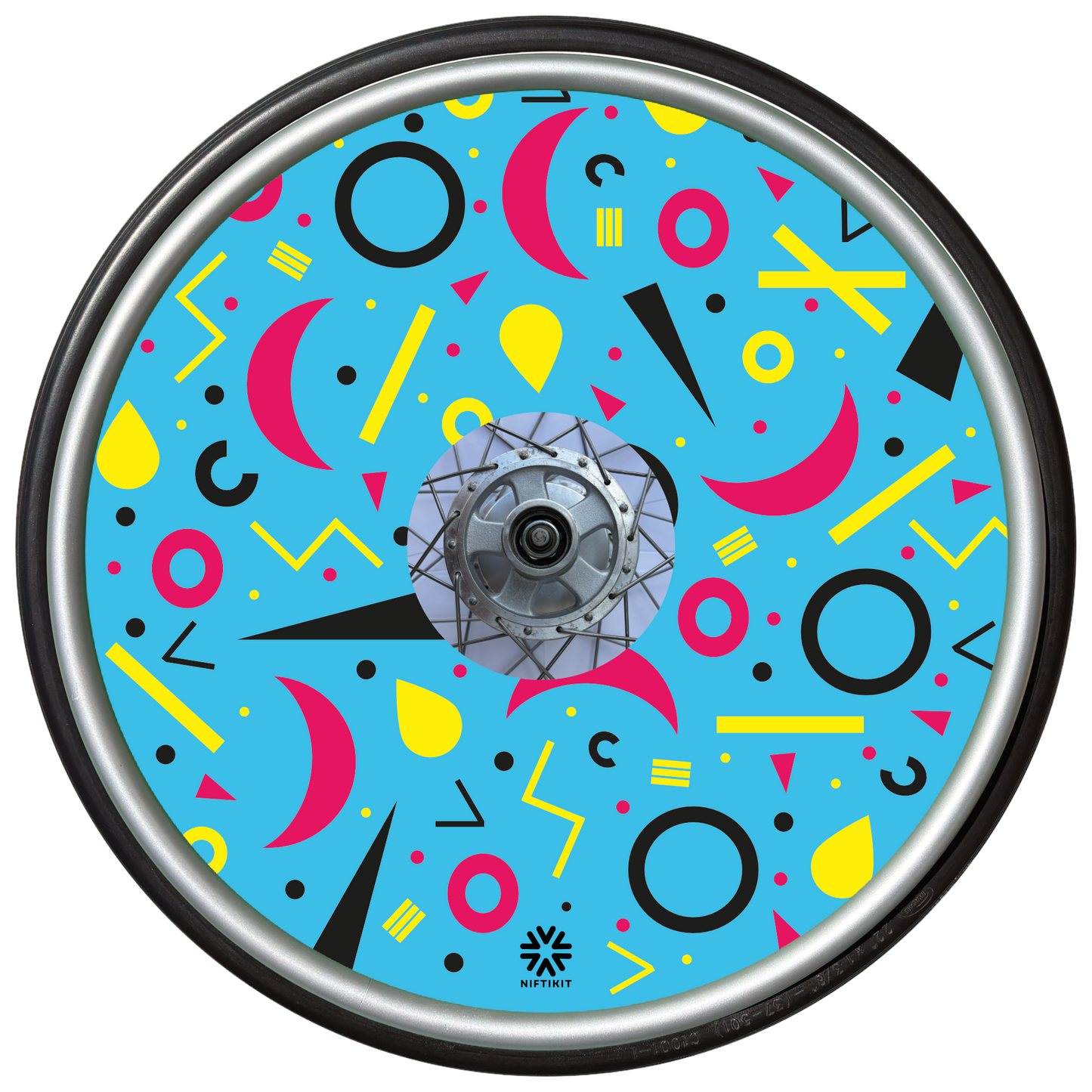 Wheelchair wheel cover with rings, lines and moons patterns in pink, black, yellow. Centre hub cutout, small Niftikit label. blue background.