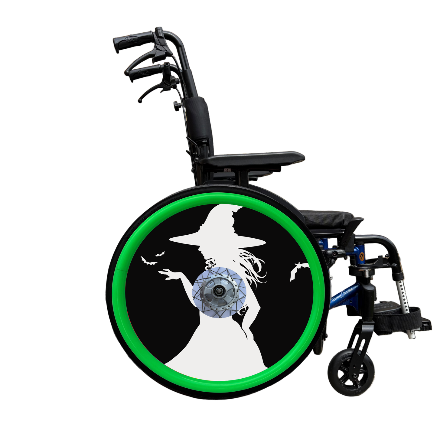 Wheelchair wheel cover on a wheel with green pushrim covers, featuring the white silhouette of a witch and bats on a black background.