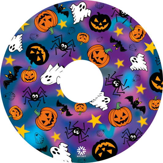A wheelchair wheel cover or disc with centre cut out, featuring a colorful Halloween pattern with pumpkins, ghosts, bats, spiders, and stars on a purple and blue gradient background.