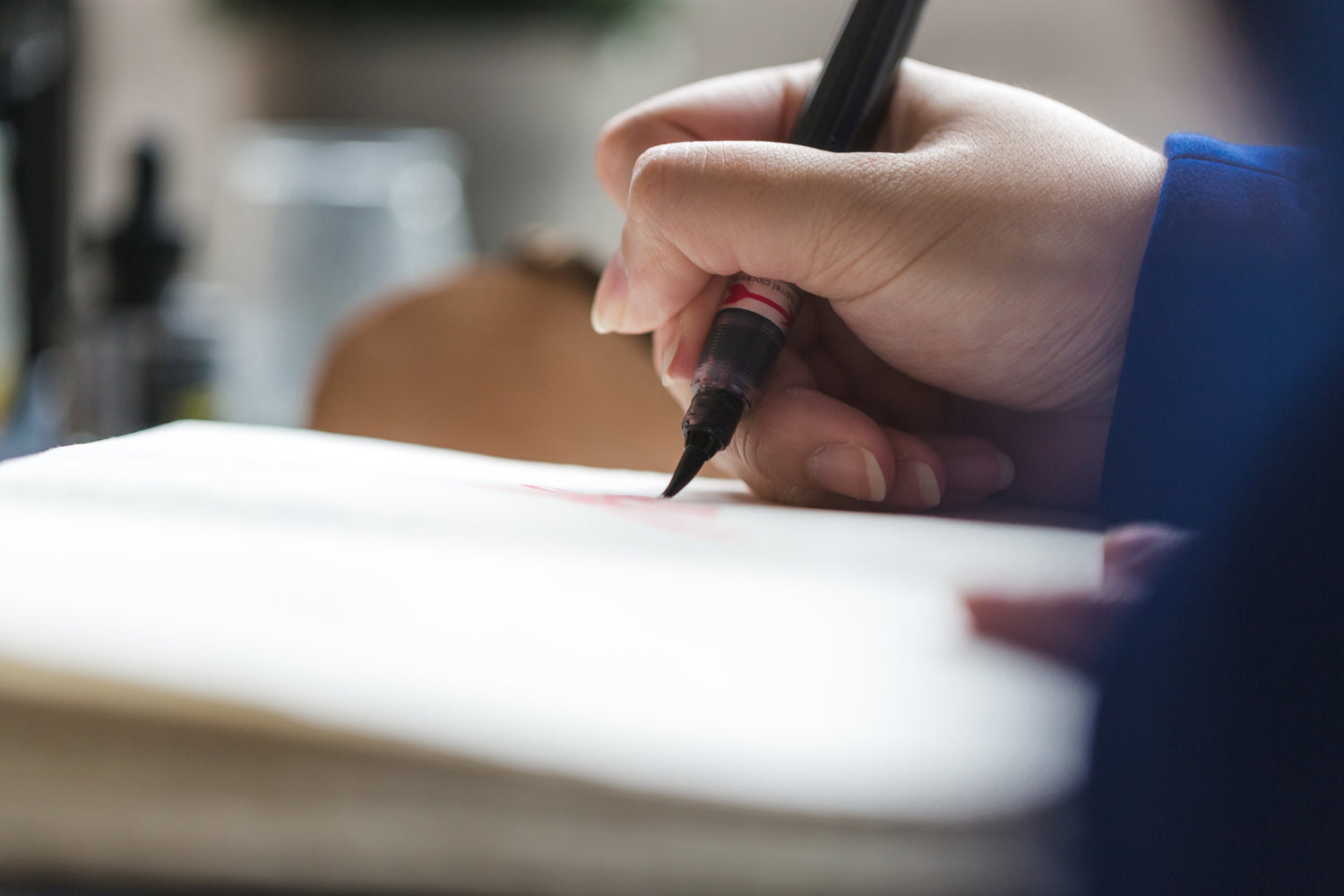 Calligraphy artist writing with pen on paper