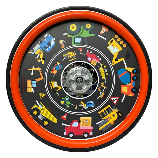 Wheelchair wheel featuring a orange silicone hand rim cover and spoke guard with colourful diggers, dumper trucks and tractors on a road background