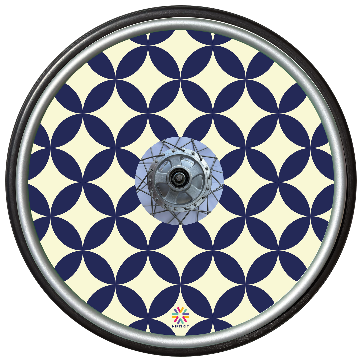 Wheelchair wheel with navy blue and cream geometric petals and diamonds pattern on a spoke guard cover with centre hub cutout.