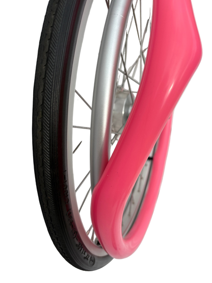 Close up of wheelchair wheel showing removal of pink silicone Handrim cover, Push rim cover