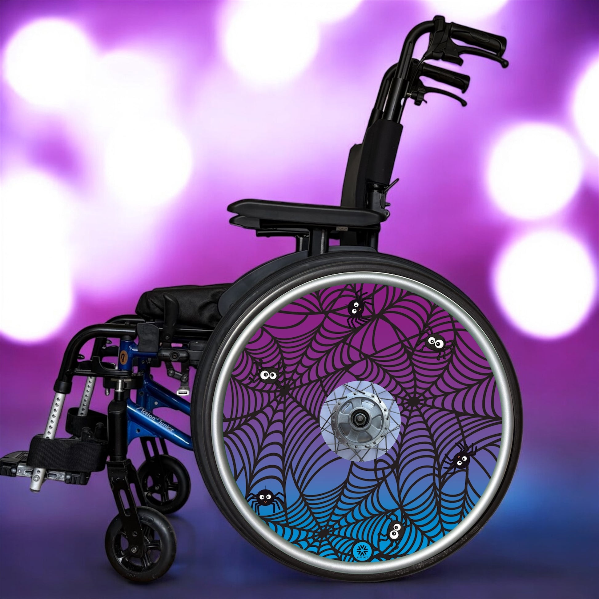 Wheelchair wheel cover on a wheelchair featuring spiders on spider webs on a purple background.