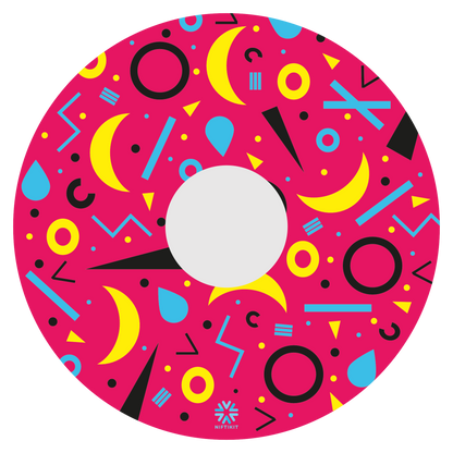 Spoke guard disc with rings, lines  and moons patterns in black, blue, yellow. Centre hub cutout, small Niftikit label. pink background. 