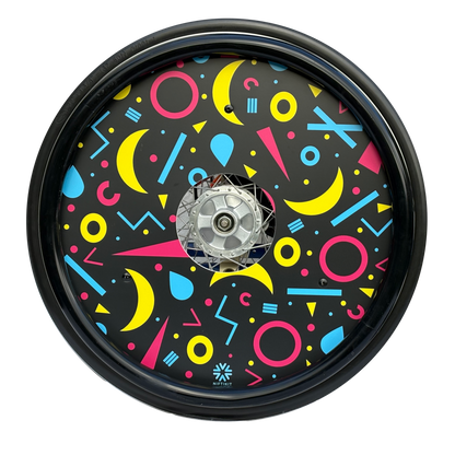 Wheelchair wheel featuring a black silicone hand rim cover and spoke guard with geometric moons, circles and lines on black background