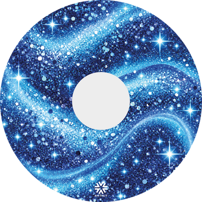 A wheelchair wheel guard with a blue glittery galaxy pattern and a 135mm center hole, shown on a plain white background. A small Niftikit logo at the bottom 
