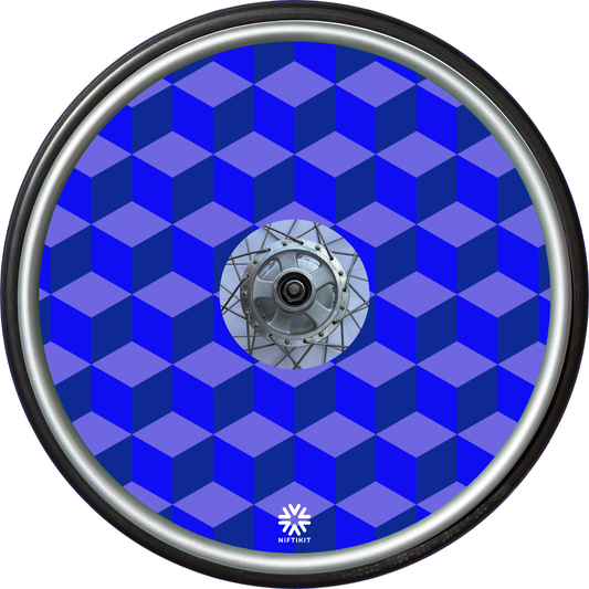 Wheelchair wheel with blue geometric-blocks patterned spoke guard cover with a small white visible Niftikit logo.