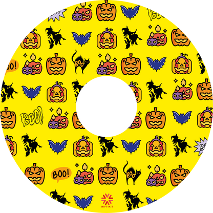 Wheelchair wheel cover featuring pumpkins, bats, witches and Boo! on a yellow background.