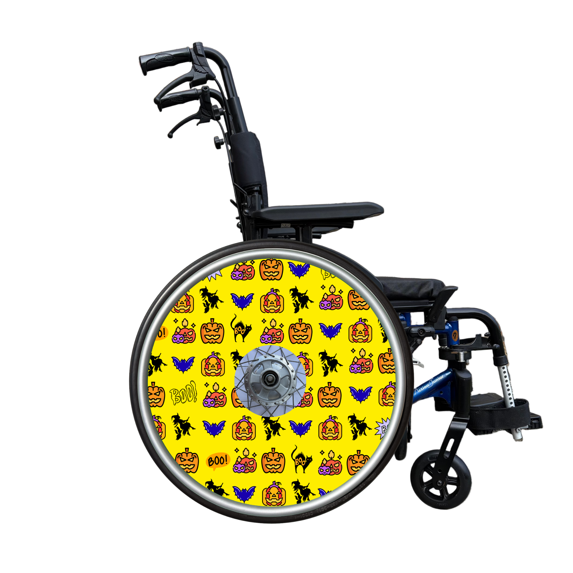 Wheelchair wheel cover on a wheelchair featuring pumpkins, bats, witches and Boo! on a yellow background.