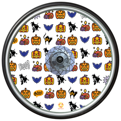 Wheelchair wheel cover on a wheel featuring pumpkins, bats, witches and Boo! on a white background.
