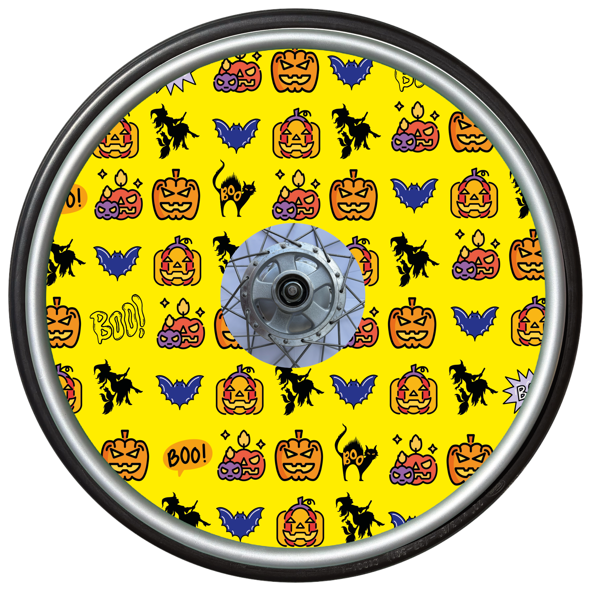 Wheelchair wheel cover on a wheel featuring pumpkins, bats, witches and Boo! on a yellow background.