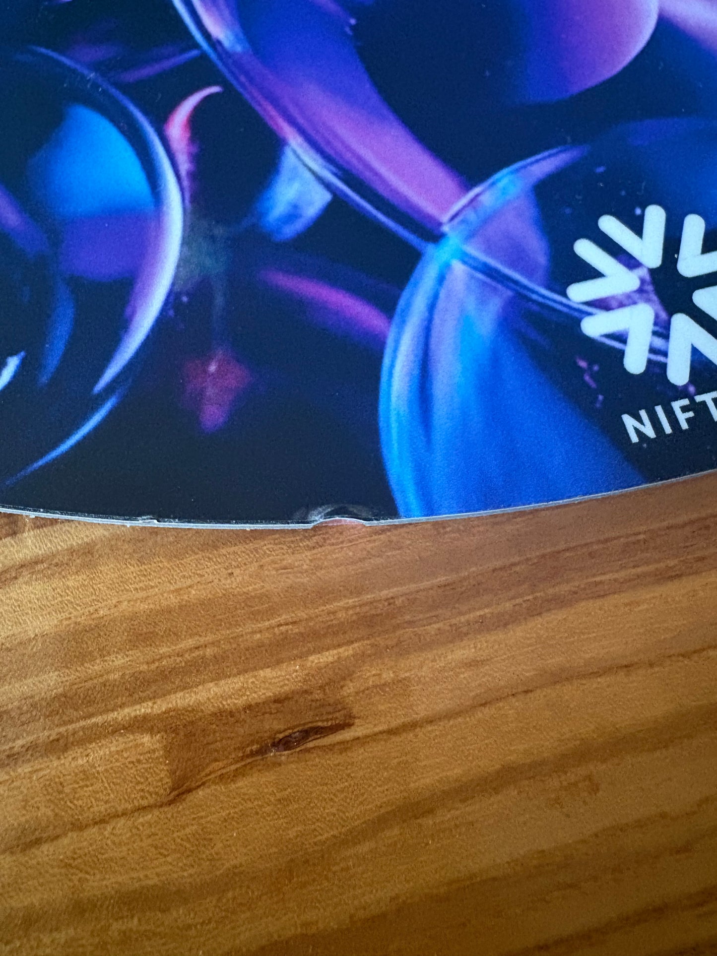Close-up of spoke guard product 3mm edge mark. Blue and purple  bubble design on a wooden surface