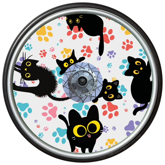 Wheelchair wheel cover on a wheel featuring black cats with orange eyes and colourful paw prints on a white background.