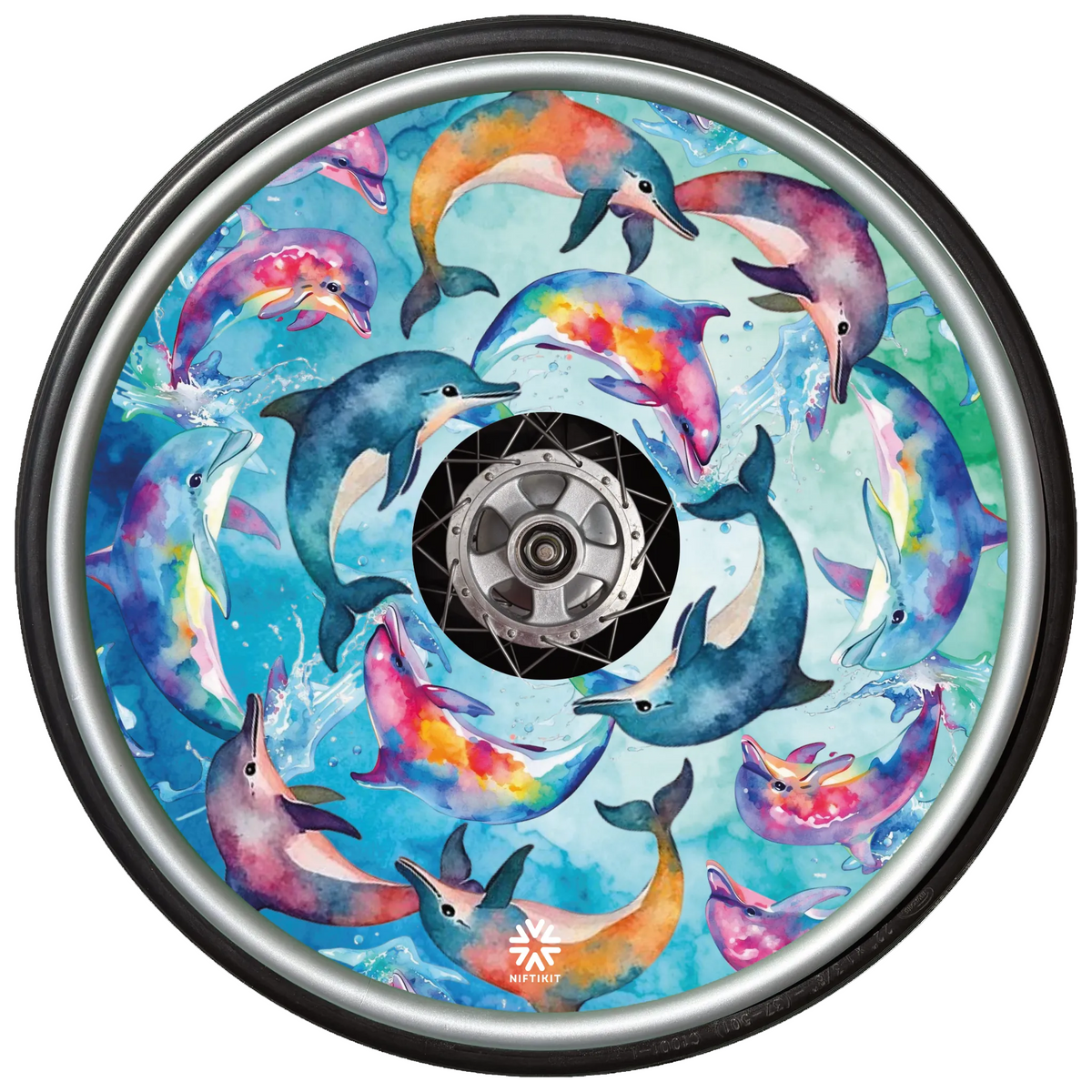 A wheelchair wheel featuring a colorful watercolor print of dolphins swimming in blue water, with a black outer tire and a silver metallic hub visible in the center.