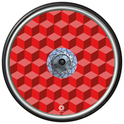 Wheelchair wheel with red geometric-bricks patterned spoke guard cover with a small white visible Niftikit logo.