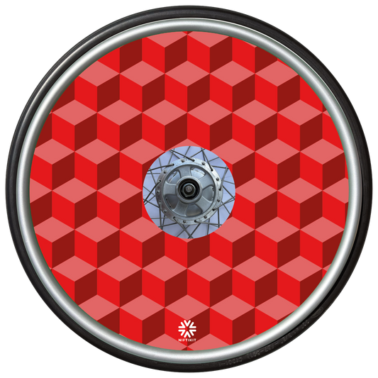 Wheelchair wheel with red geometric-bricks patterned spoke guard cover with a small white visible Niftikit logo.