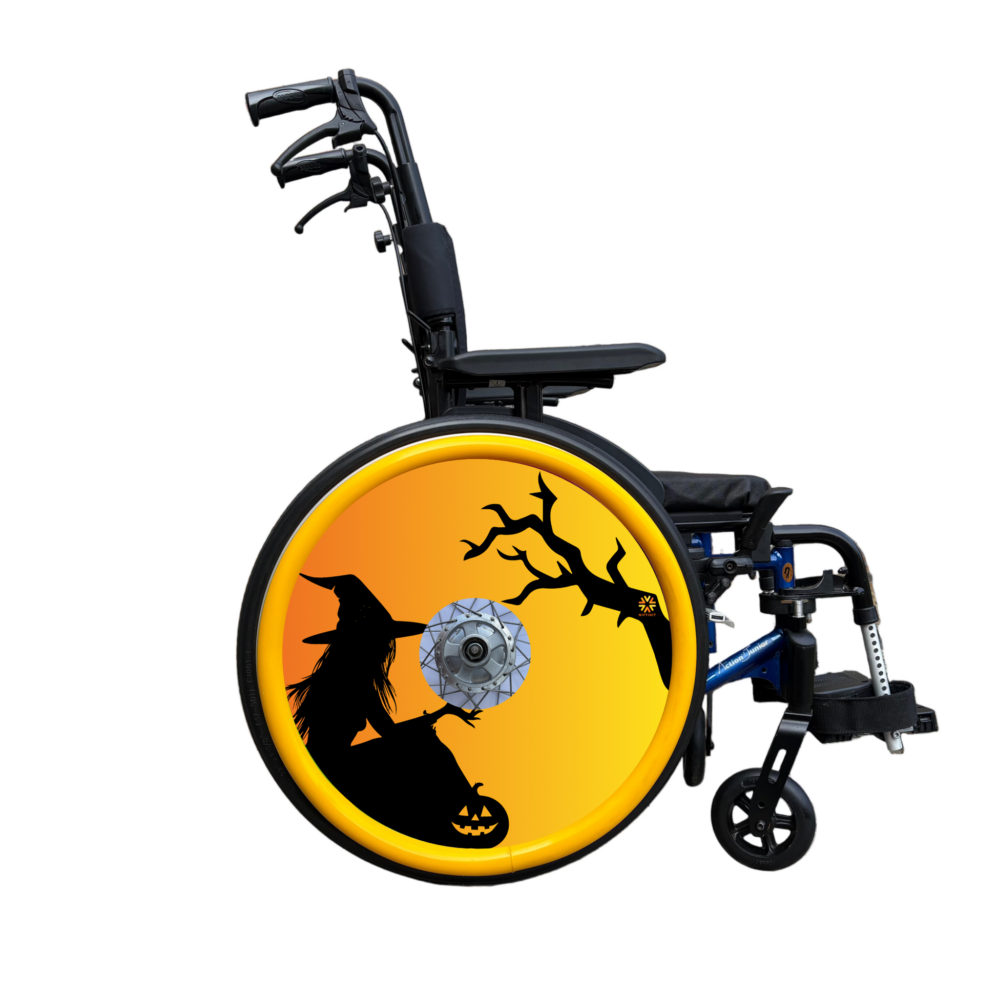 Wheelchair with a wheel cover on its wheel with the silhouette of a witch and tree on an orange background