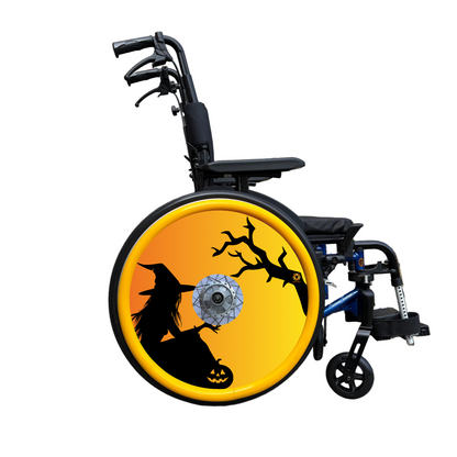 Wheelchair with a wheel cover on its wheel with the silhouette of a witch and tree on an orange background