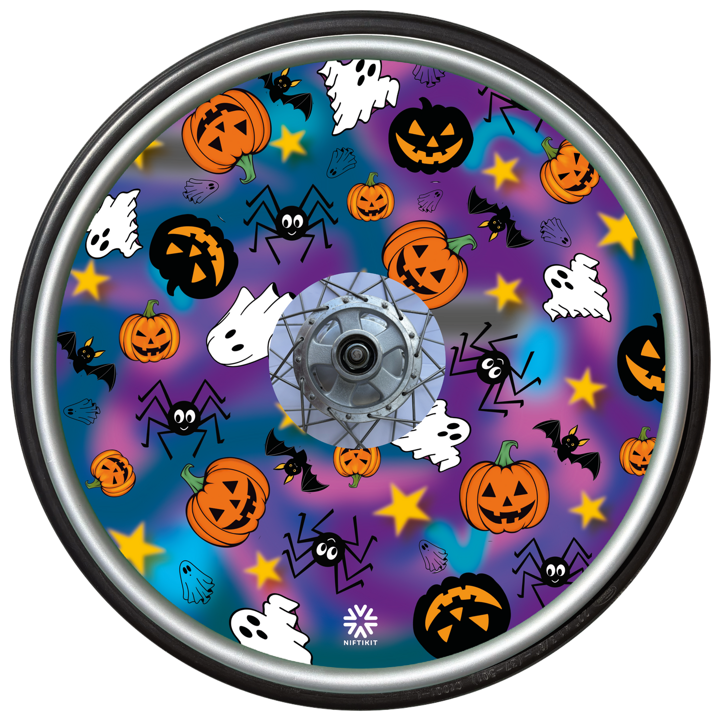 Wheelchair wheel cover on a wheel featuring spiders, ghosts, pumpkins and bats on a blue and purple background.
