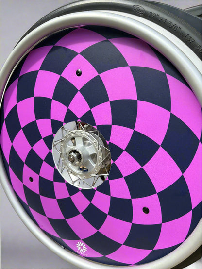 Wheelchair wheel with spoke cover with navy and purple diamonds  pattern, 3 black rivets and small white Niftikit logo. 