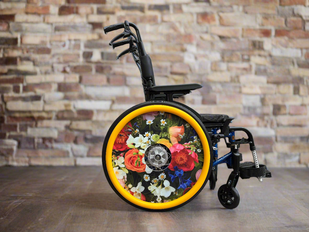 Wheelchair featuring a wheel cover with a enlarged photo of vibrant British flowers , with matching yellow silicone hand rim cover.