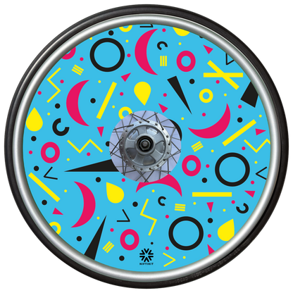 Wheelchair wheel cover with rings, lines  and moons patterns in pink, black, yellow. Centre hub cutout, small Niftikit label. blue background. 