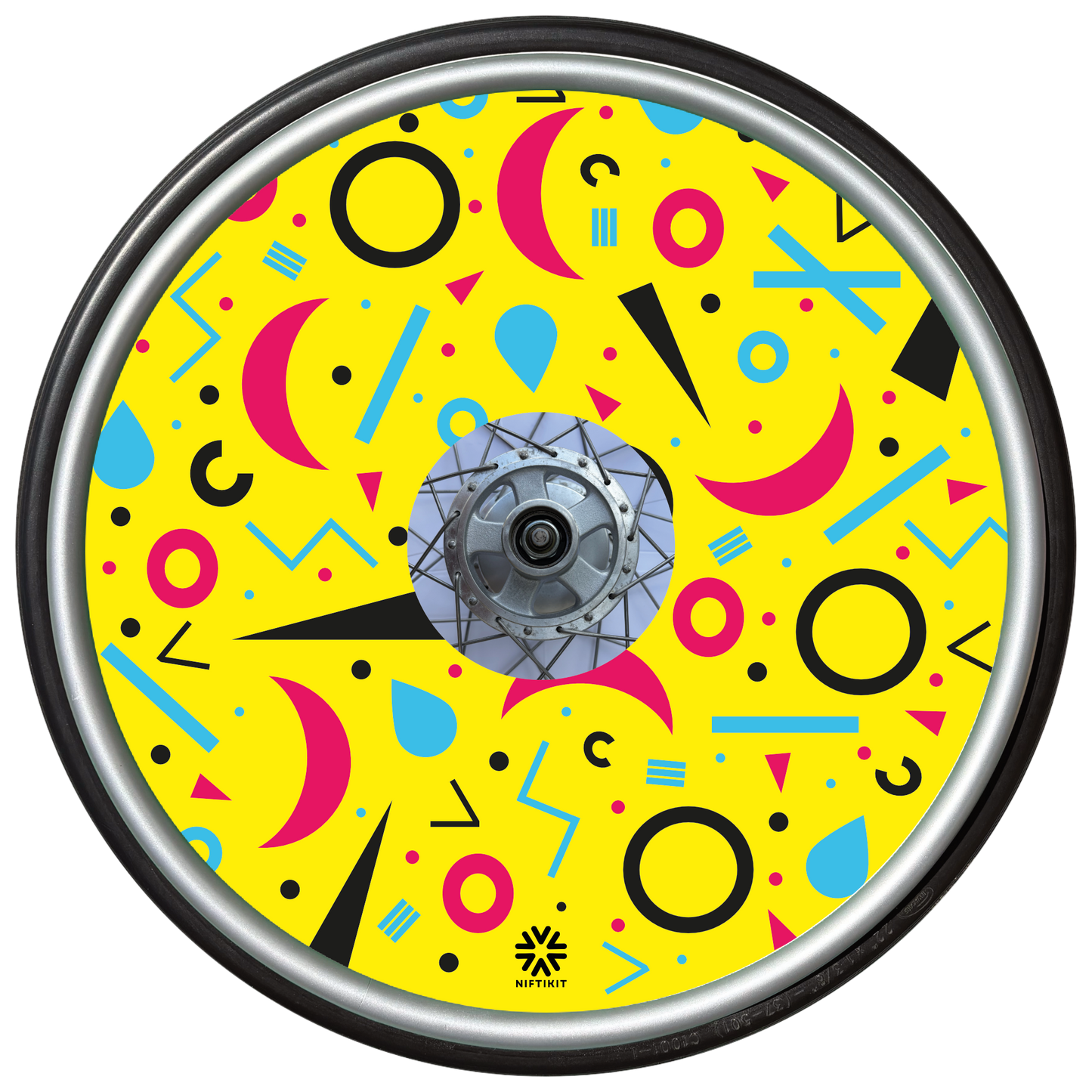 Wheelchair wheel cover with rings, lines  and moons patterns in pink, blue, black. Centre hub cutout, small Niftikit label. Yellow background. 