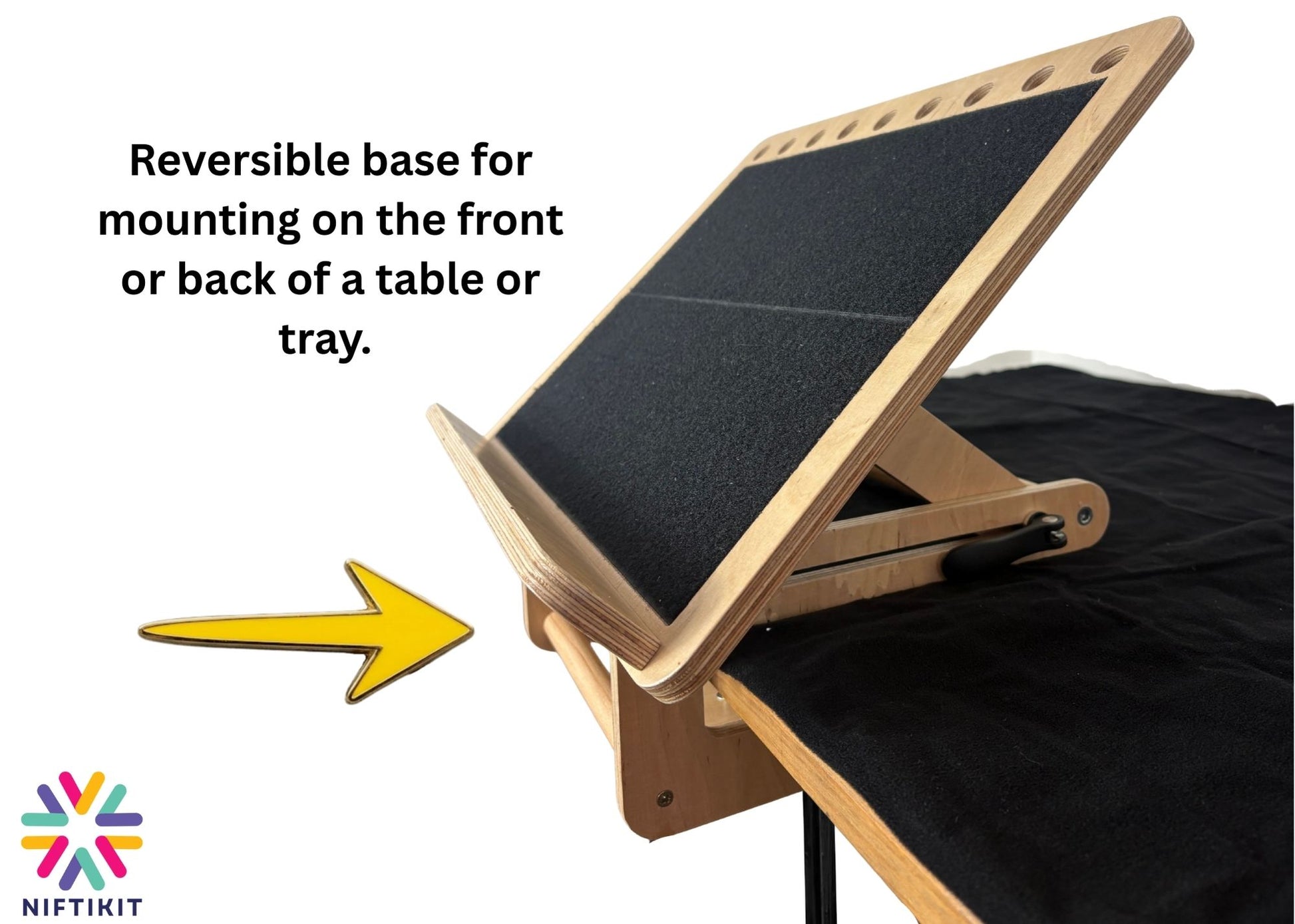 Side angle of Niftikit desk slope affixed to the front of a table with a bright yellow arrow showing direction of insertion. 