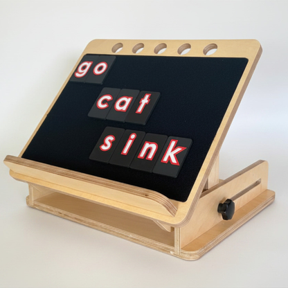 Beautiful wooden desk slope with CVI friendly tactile letter tiles displaying the words 'go cat sink' on a white background