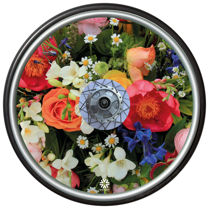 Wheelchair wheel featuring a wheel cover with a enlarged photo of vibrant British flowers including roses, bluebells, daisy's and mixed foliage.  