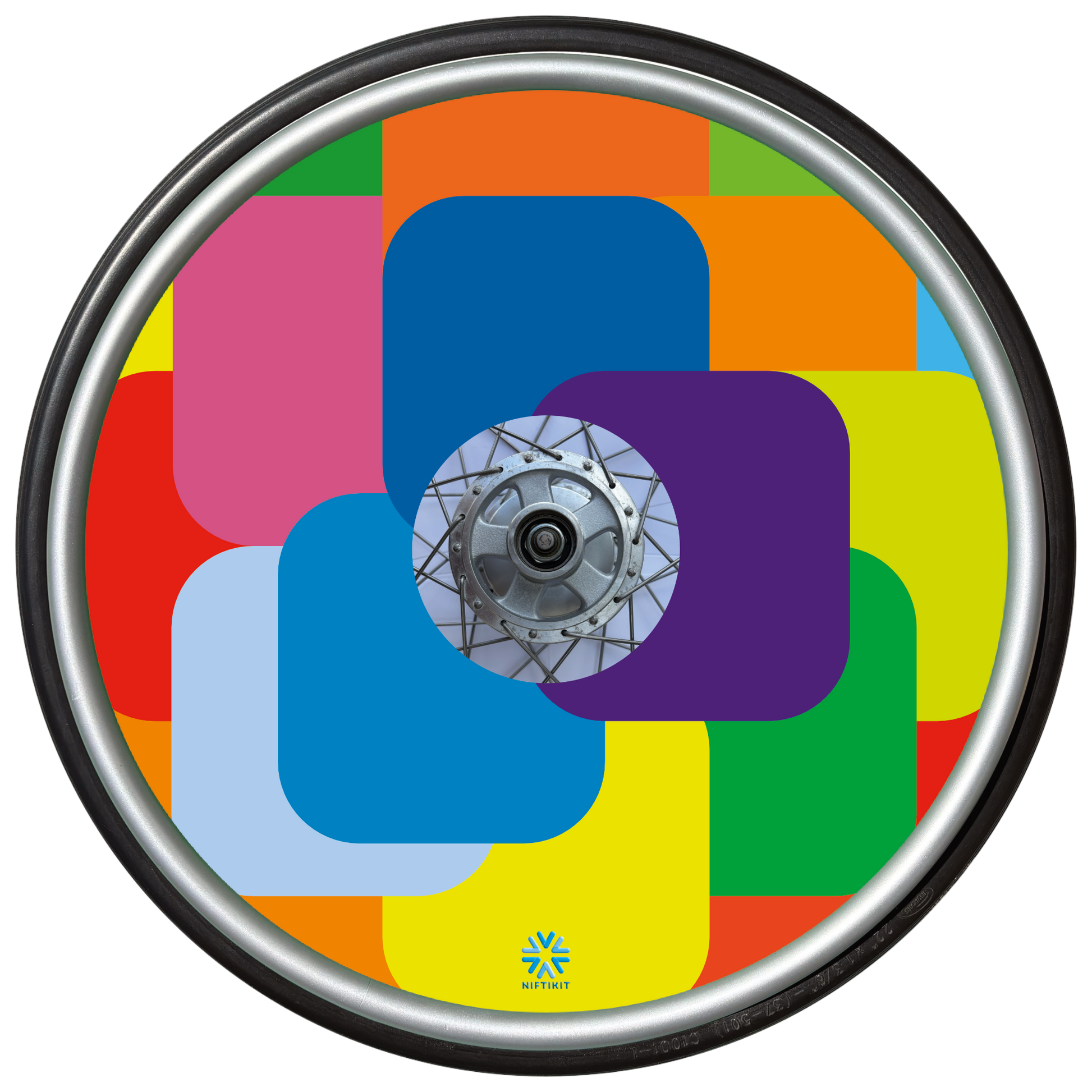 Bright and colorful geometric, squares patterned wheel cover on a wheel chair wheel with small blue Niftikit logo. 
