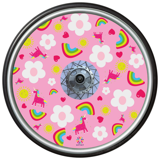 Wheelchair wheel cover with bright rainbows and unicorns on a baby pink background with cartoon white flowers. 