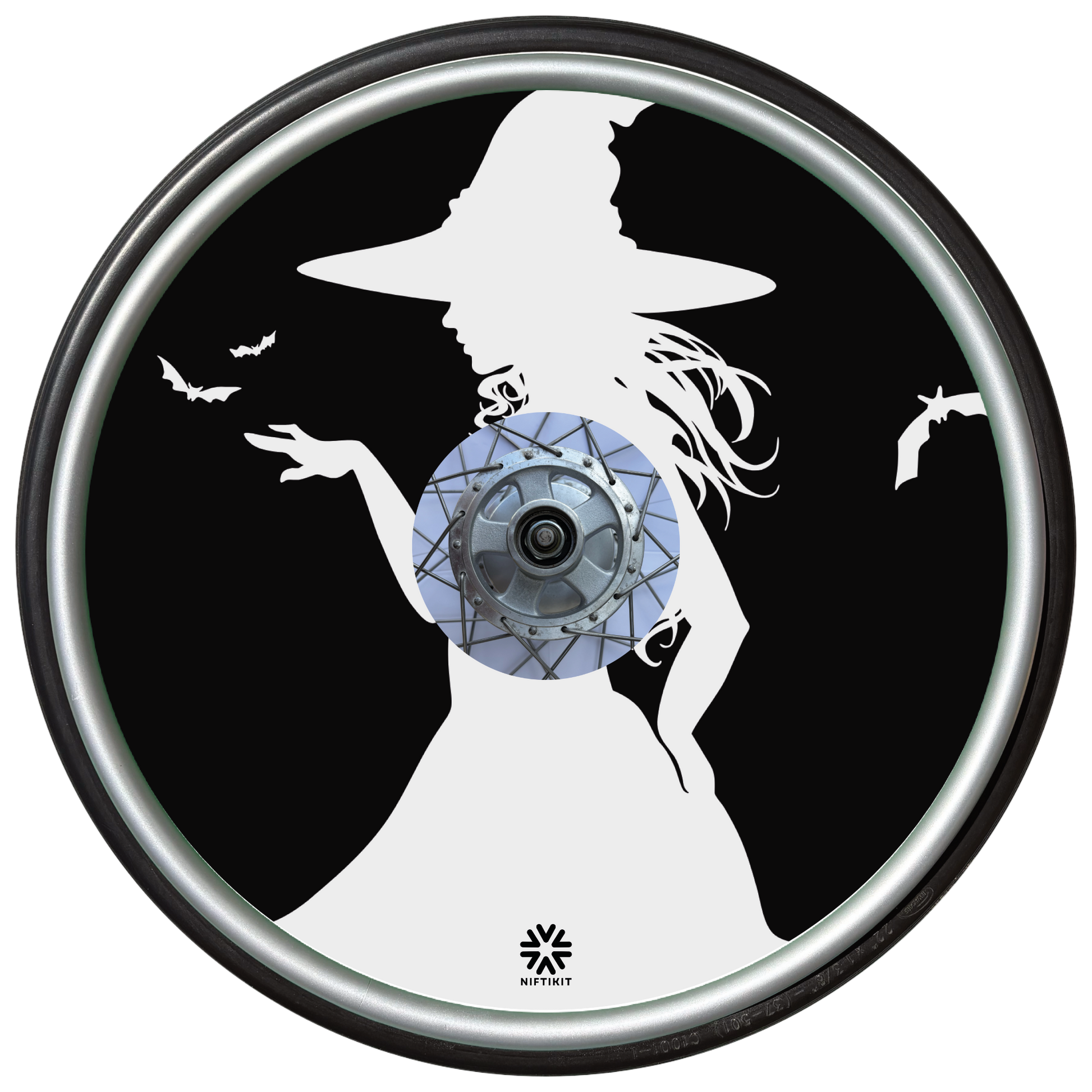 Wheelchair wheel cover on a wheel featuring the white silhouette of a witch and bats on a black background.