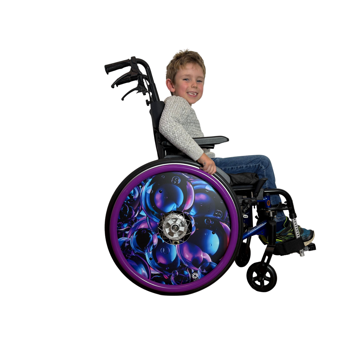 Child in wheelchair with spoke guard  featuring pueple/navy geometric design finished with a bright purple silicone push rim cover for grip and comfort.
