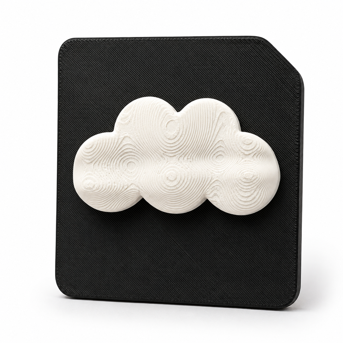 A 3D tactile cloud weather symbol on black high contrast tile. Showing a raised cloud for sensory learning tactile discrimination for blind and visually impaired 
