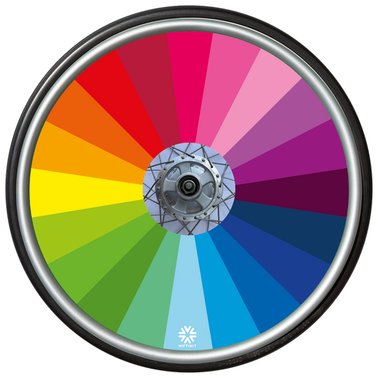 Wheelchair wheel featuring a spoke guard cover with rainbow colour spectrum fanning out from the centre. 