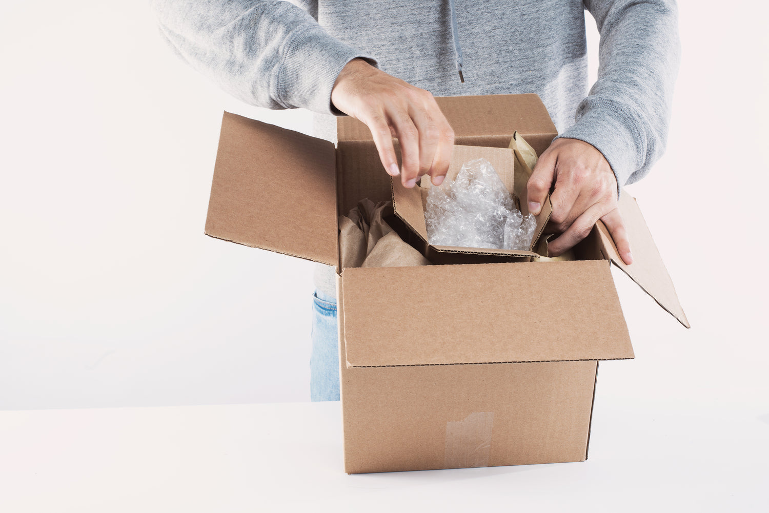 Close up of a person packing a box and a white background